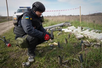 A sapper of the Ukrainian State Emergency Service collects remains of shells, grenades and other devices at the demining site near village of Kamenka, Kharkiv region, Ukraine, on April 11, 2023.