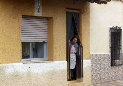 Una vecina de El Salobral en Albacete observa desde la puerta de su casa los movimientos de la Guardia civil.