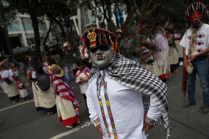 Un hombre enmascarado mira a la cámara, durante la marcha, sobre la avenida Paseo de la Reforma.