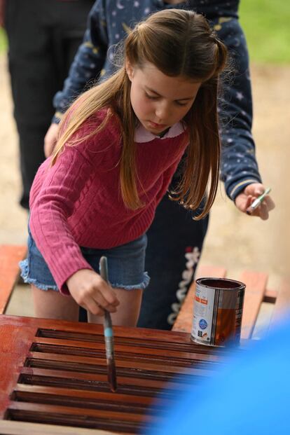 Los príncipes han ayudado con las actividades en Slough en un día especial para la familia real británica. La princesa Carlota, en esta imagen, barniza un mueble de madera. 