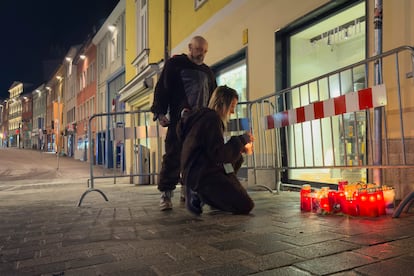 Una persona enciende una vela en el lugar del ataque, este domingo en Villach (Austria).