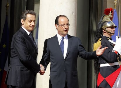 El todavía presidente Nicolas Sarkozy saluda a François Hollande en la entrada del palacio del Elíseo antes de comenzar la ceremonia de traspaso de poder.
