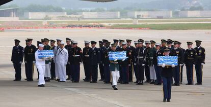 La guardia de honor de la ONU transporta las cajas con los restos procedentes de Corea del Norte.