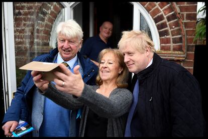 Boris Johnson junto a su padre, Stanley, se hacen una foto con una votante conservadora en 2019.