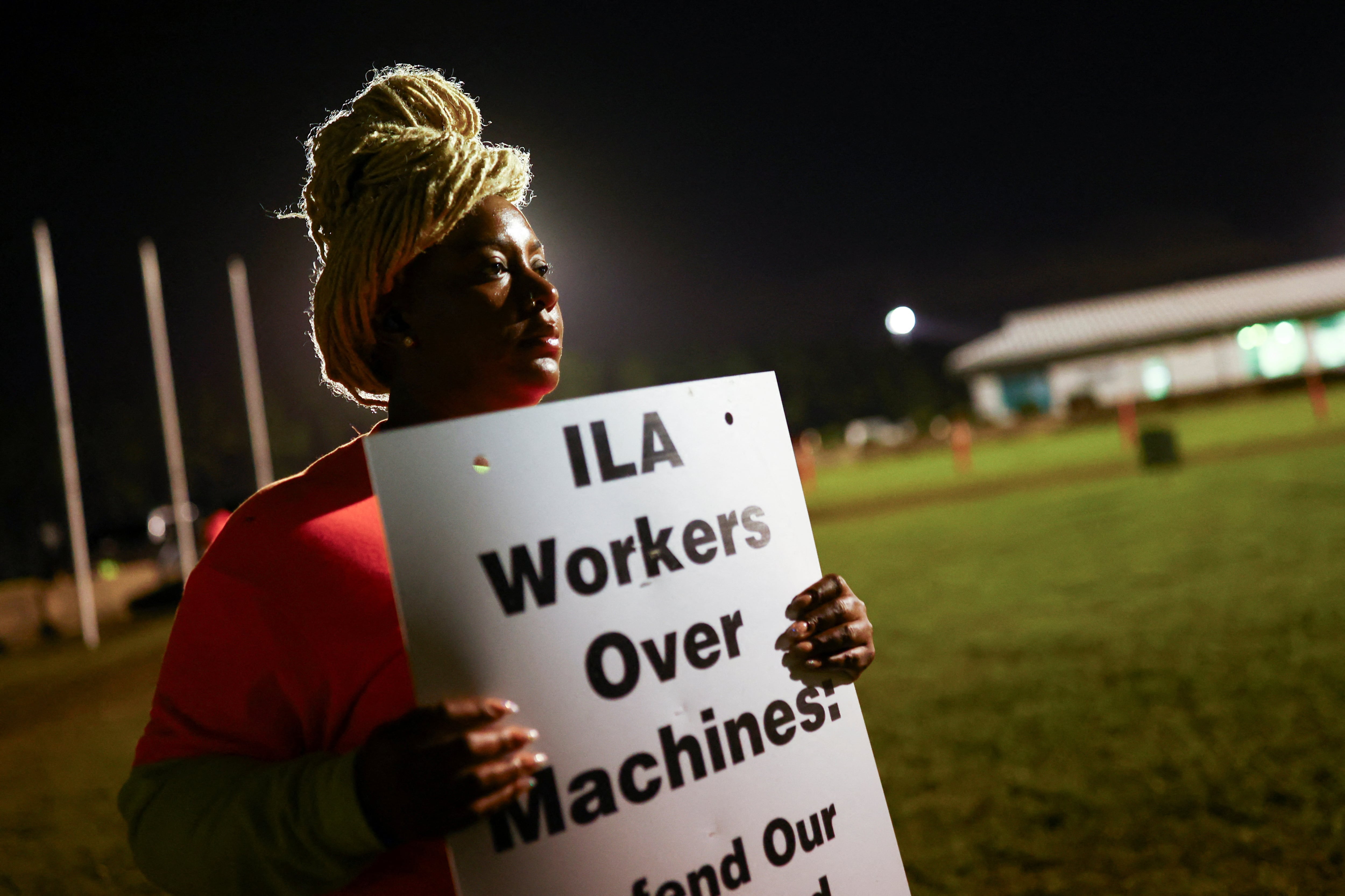 Una estibadora porta una pancarta contra la automatización de puestos de trabajo, este martes en el puerto internacional de Virginia, en Portsmouth.