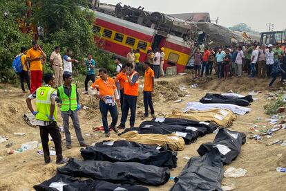 Cuerpos apilados este sábado en los aledaños del accidente de trenes ocurrido en la India. 