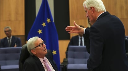 El jefe de la UE para la negociación del Brexit, Michel Barnier (en pie), habla con el presidente de la Comisión, Jean Claude Juncker.