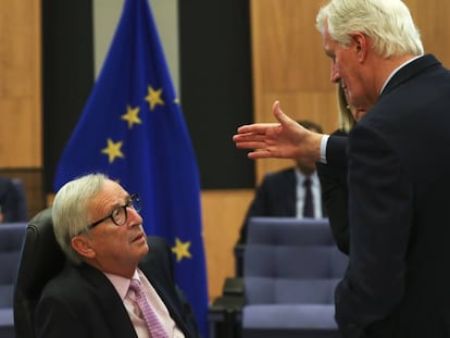El jefe de la UE para la negociación del Brexit, Michel Barnier (en pie), habla con el presidente de la Comisión, Jean Claude Juncker.