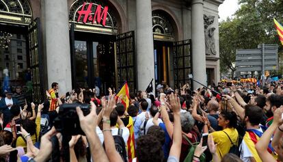 Manifestants demanen el tancament d'un comerç durant la vaga general.