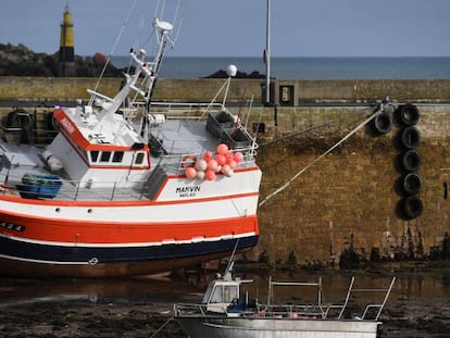 Un barco, encallado en la arena durante la marea baja en el puerto Roscoff, Francia. 