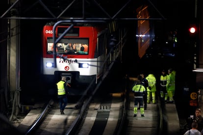 Varios operarios junto al tren de Cercanías que descarriló este martes en la entrada de la madrileña estación de Atocha.