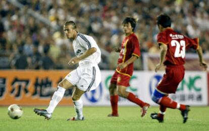 Beckham golpea el balón entre dos jugadores chinos en su primer partido con la camiseta del Madrid.