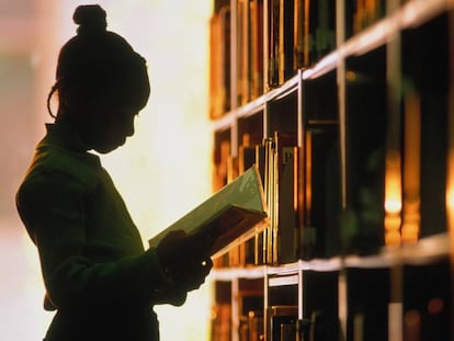 Una noia en una biblioteca.