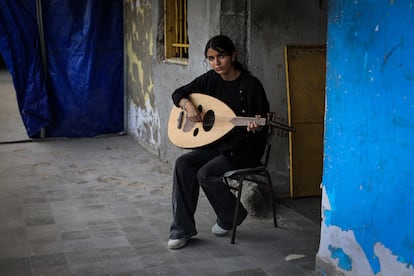 "Cuando toco, siento que estoy volando. La música me da esperanza y alivia mi miedo", dice Rifan al Qassas, de 15 años, que comenzó a aprender a tocar el oud, un laúd árabe, cuando tenía nueve años. Al Qassas [en la fotografía] espera poder tocar algún día en el extranjero, asegura durante una clase de fin de semana en el Gaza College, el 9 de agosto de 2025. 