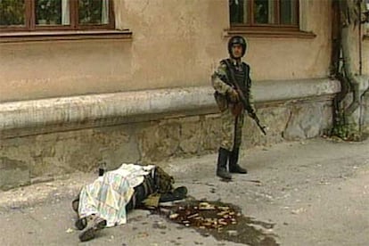 Un soldado ruso, junto a un cadáver en una calle de Nálchik, en una foto tomada de la televisión.