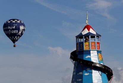 Un hombre observa desde una torre junto a un globo aerostático que se eleva durante la feria del condado de Chatsworth House, cerca de Bakewell (Inglaterra).