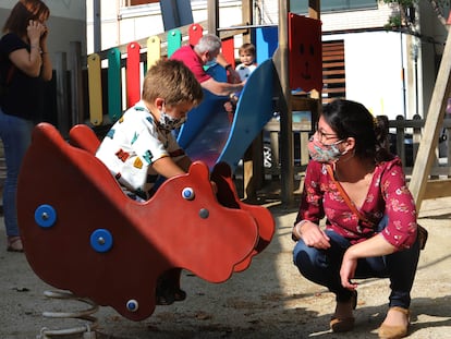 Varios padres, con sus hijos, en un parque infantil en Terrassa.