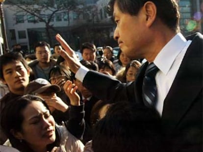 Hwang Woo-suk saluda a sus estudiantes al abandonar ayer la Universidad de Seúl.