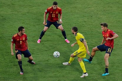 El delantero sueco Marcus Berg trata de pasar el balón a un compañero ante la presión de varios jugadores de la selección española.