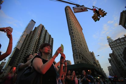Los ciudadanos de Manhattan hacen fotos al atardecer junto al edificio Flatiron.