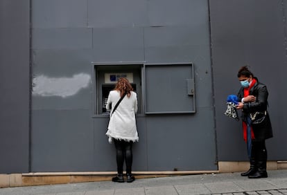 Mulher saca dinheiro de caixa eletrônico em Beirute, nesta terça.