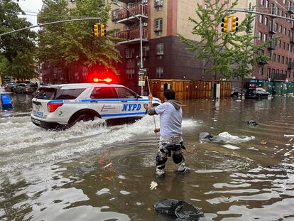 A man works to clear a drain in flood waters, Friday, Sept. 29, 2023, in the Brooklyn borough of New York.