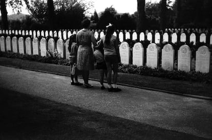 Las niñas y la mujer protagonistas de la mayoría de imágenes de la exposición 'Randstad 1969', conformada por imágenes de los sesenta que estaban revelar, observan las lápidas de un cementerio.