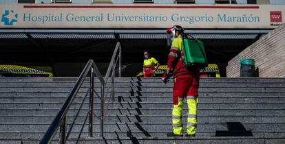 Un operario desinfecta el pasamanos de la escalera de la entrada principal del hospital Gregorio Marañón.