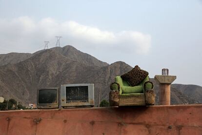 Televisiones junto a un sillón sobre un puente peatonal, en Carapongo Huachipa, Lima.