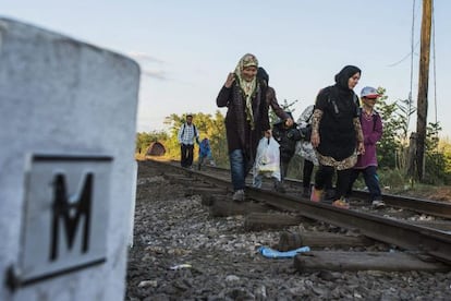 Refugiados caminham próximos à fronteira da Hungria.