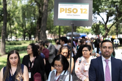 Oficinistas hacen una fila sobre la Alameda Central, en la capital mexicana.