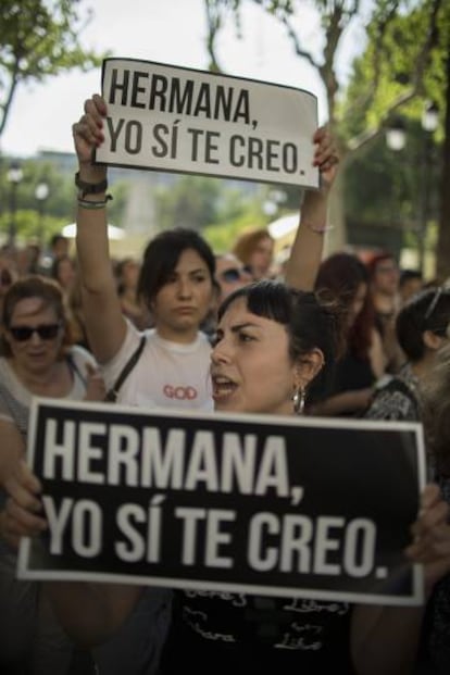 Protesters in Seville hold up signs reading "Sister, I believe you."