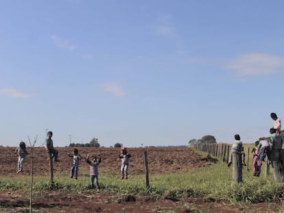 Estudantes da escola indígena da aldeia Guyraroká brincam na cerca com a fazenda vizinha da comunidade.