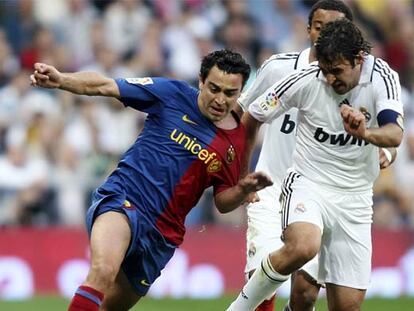 Xavi disputa el balón con Raúl.