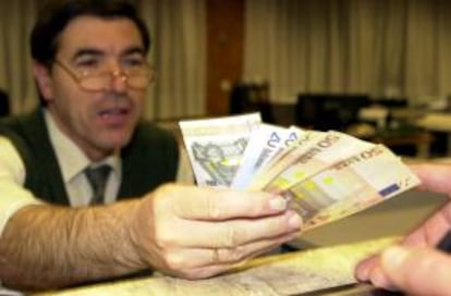 Un empleado de banca muestra unos billetes de euro. EFE/Archivo