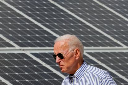 Joe Biden durante la campaña presidencial camina junto a un conjunto de paneles solares en Plymouth, New Hampshire.