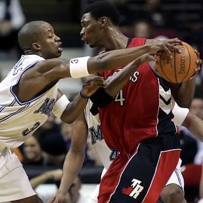 Chris Bosh, de los Raptors (dcha.) disputa el balón a Steve Francis, de Orlando.