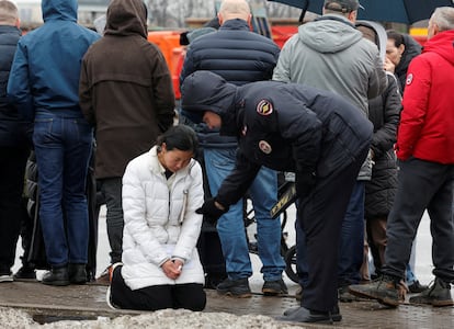 Un agente de policía ruso consuela a una mujer que muestra su tristeza este sábado tras el ataque terrorista en la sala de conciertos Crocus, en Krasnogorsk. 