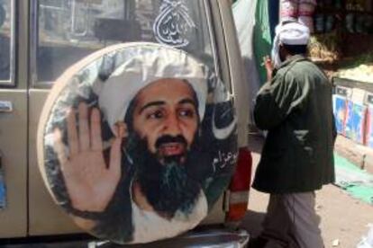 Un hombre pasa junto a un cartel del fundador de la organización terrorista Al Qaeda, Osama bin Laden. EFE/Archivo