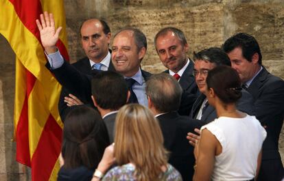 Francisco Camps, rodeado de sus colaboradores, saluda tras anunciar su dimisión como presidente de la Generalidad.