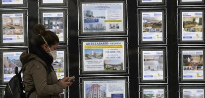 Una mujer pasa ante el escaparate de una inmobiliaria en Bilbao, durante el estado de alarma.