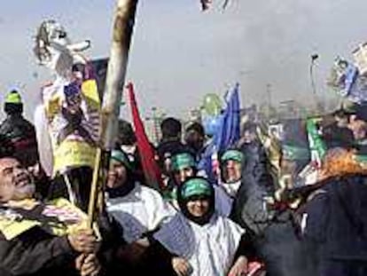Un grupo de iraníes quema una imagen del Tío Sam con la cara de George Bush.