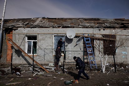 Varios hombres arreglan las ventanas de una casa tras ser bombardeada en Byshiv, en las afueras de Kiev. El ministro de Economía suizo, Guy Parmelin, se mostró hoy contrario a imponer sanciones sobre el comercio de materias primas con Rusia, algo que en su opinión "podría tener efectos secundarios a nivel global".