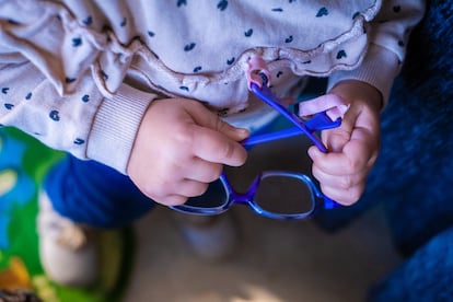 Salma, una niña de dos años, coge sus gafas que sus padres están pagando a plazos porque suponen el 82% del sueldo que entra en casa.