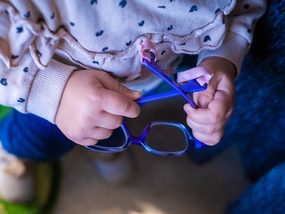 Salma, una niña de dos años, coge sus gafas que sus padres están pagando a plazos porque suponen el 82% del sueldo que entra en casa.