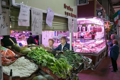 Un hombre y una mujer compran hortalizas en el mercado de la Cebada, en el distrito Centro de Madrid, el 28 de marzo de 2023.