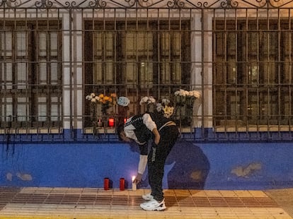 Un joven coloca una flor en el altar espontáneo que los vecinos de Argamasilla de Calatrava han colocado para homenajear a Javier, el policía local asesinado.