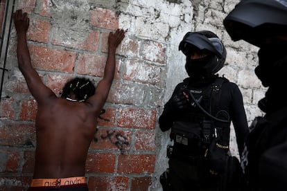 Policías inspeccionan a un hombre en Guayaquil, este viernes.