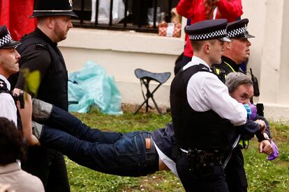 Los agentes de policía detienen a un miembro del movimiento Just Stop Oil antes del paso de la comitiva real en la ceremonia de la coronación.