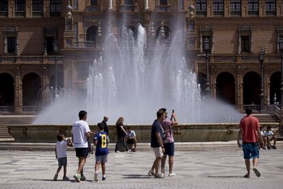 Varios turistas junto a la fuente de la Plaza de España (Sevilla).